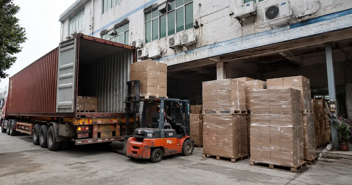 Shipping containers and palletized cartons of party supplies ready for export at a Chinese factory loading dock