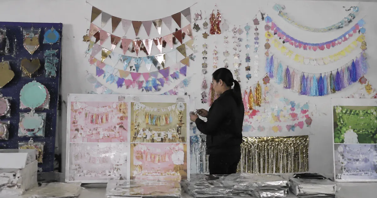 Assorted seasonal party decorations including Halloween, Christmas, and birthday themed bunting and banners in a factory display